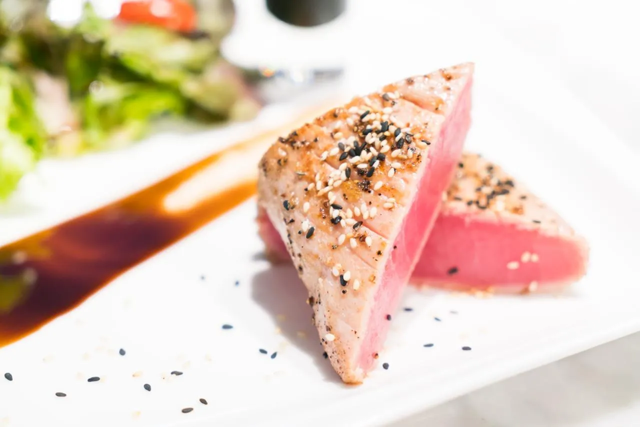 Sesame-crusted seared tuna steak, sliced to show the rare pink centre
