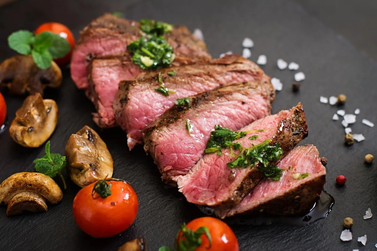 Char-grilled beefsteak, sliced and served medium-rare with herbs and tomatoes
